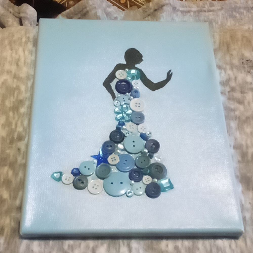 Hand-painted and decorated work of art; woman in a dress of beads and buttons.